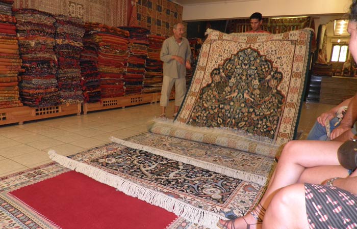 El dueño de la tienda de alfombras muestra el género un día en Tánger