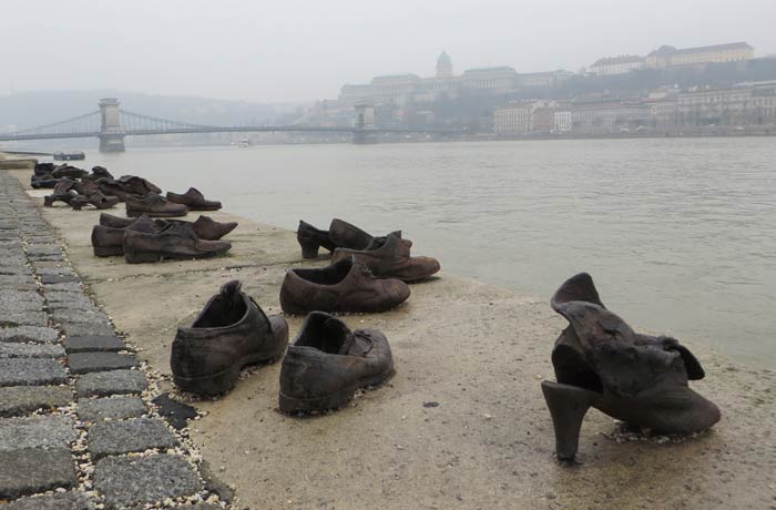 Detalle de los zapatos a la orilla del Danubio con el puente de Las Cadenas y el Castillo de Buda al fondo