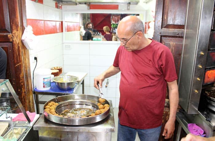 Un hombre cocina faláfel en Acre Israel por libre