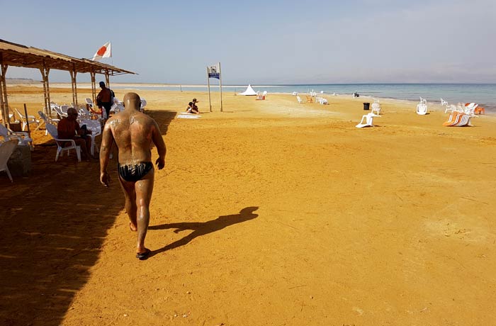 Un hombre cubierto con los barros del mar Muerto en Israel