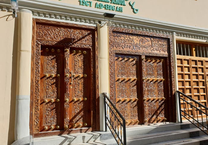 Puerta árabe con pasajes del Corán labrados en la madera